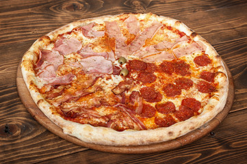 Fresh italian four seasons pizza on wooden background, side view