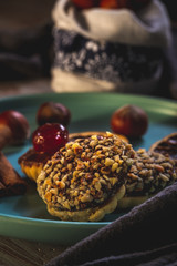 Few pieces of baked sweets with nut pieces and chocolate on blue plate