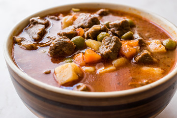 Tasty Hungarian Hot Goulash Soup Bograch or Gulas Lamb Meat Stew with Whole Grain Bread on Wooden...
