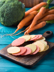 Vegan vegetable chips on wooden board