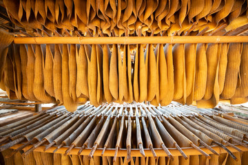 Rubber sheet hanging on wooden rack for drying.