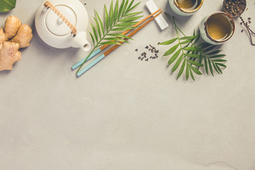 Fototapeta na wymiar Asian food background, tea and chopsticks on a grey concrete background.