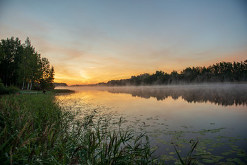 Fototapeta na wymiar colorful misty sunset on the river in summer