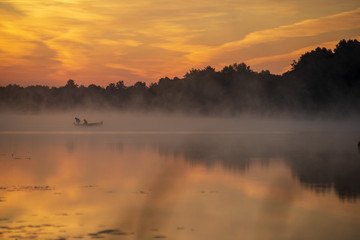 colorful misty sunset on the river in summer