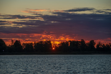 colorful misty sunset on the river in summer