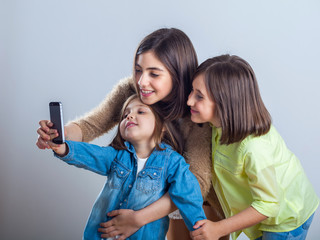 three sisters posing and taking selfies in the studio