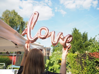 Frau hält Ballon mit Schrift