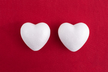 White foam heart on a red felt background