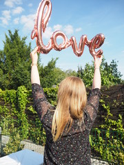 Frau hält Ballon mit Schrift