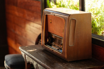 Antique radio on the wood table by the window, vintage style for decoration work .