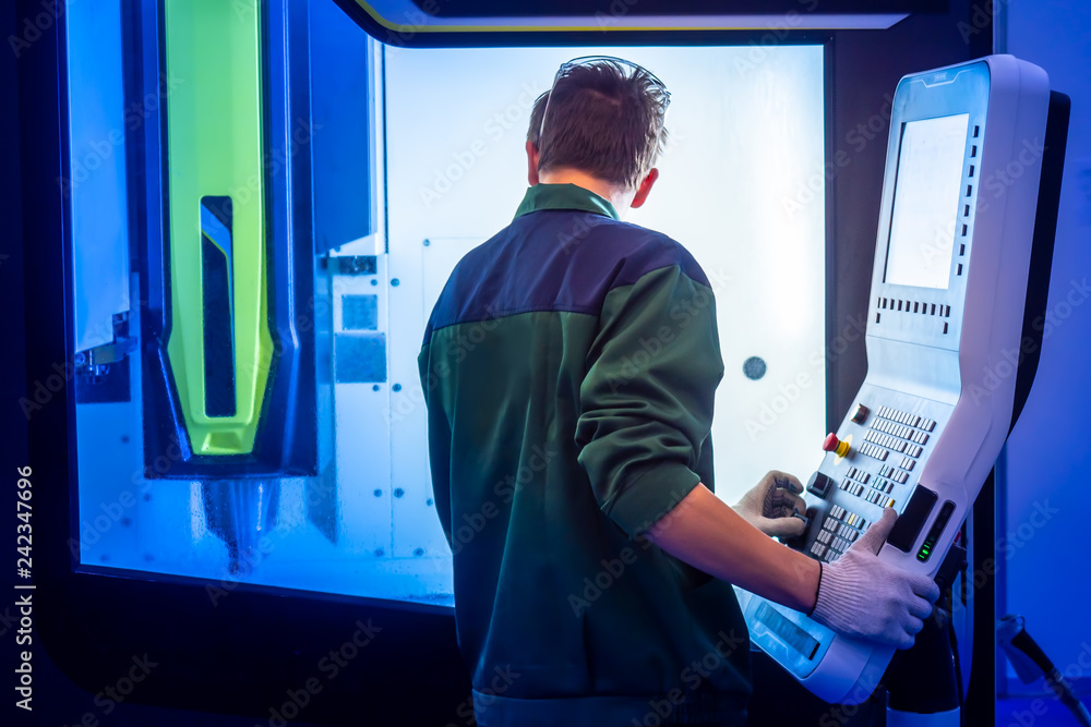 Poster machine with remote control. milling machine. the worker controls the milling machine. hand on the c