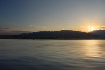 The shore of the sea and the sunset. view through the sea