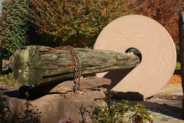 Stone and wooden log structure in a park on a sunny autumn day