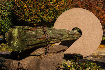 Stone and wooden log structure in a park on a sunny autumn day