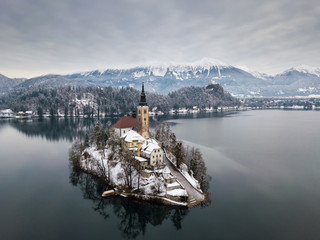Aerial shot of lake Bled on a calm winter morning with snow
