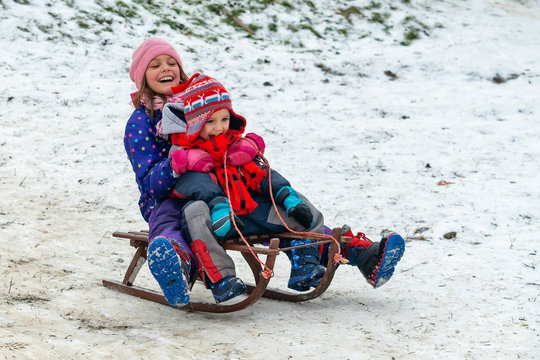 Children enjoy snowshoeing in the snow park where the grass comes out