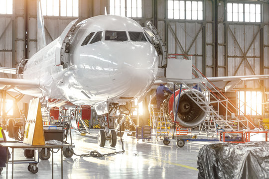 Aircraft jet on maintenance of engine and fuselage check repair in airport hangar.