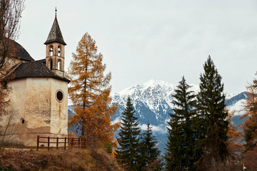 Fototapeta na wymiar Church and colorful autumn forest with mountains