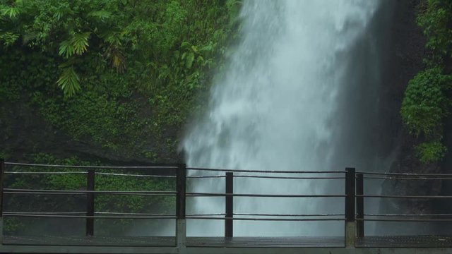 Happy young woman enjoying freedom in Sawer Waterfall at Sukabumi, West Java, Indonesia. Shot in 4k resolution