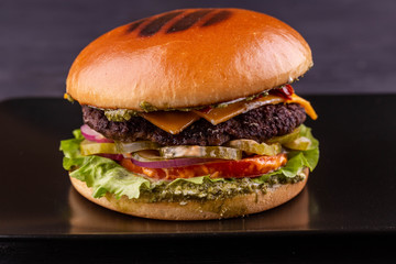 Hamburger песто with beef cutlet with cucumbers and tomatoes and cheese