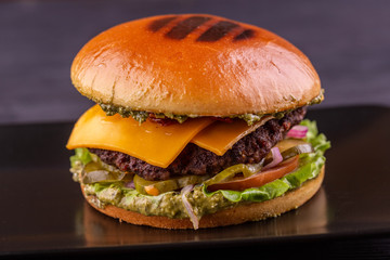 Pesto burger with cutlet, pickles and fresh tomatoes