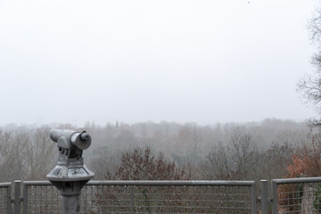 Coin operated telescope with view over trees and fog