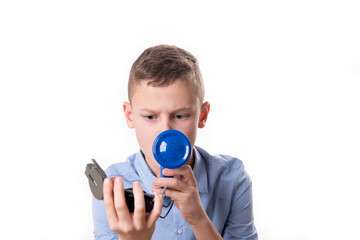 Fototapeta premium Boy explains the way with a blue megaphone and a compass in hand against a white background