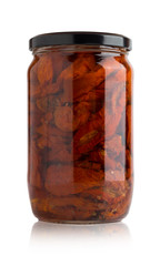 Sun-dried tomatoes in a glass jar. Slices of dried tomatoes in a jar on a white background.