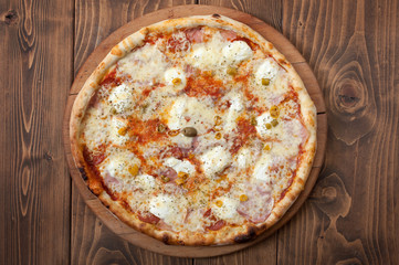 Pizza margherita on wooden background, top view
