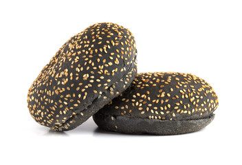 Black burger buns on a white background. Two black buns cut in half close up on a white background.