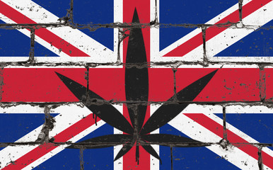 Fototapeta premium Graffiti street art spray drawing on stencil. Cannabis leaf on brick wall with flag United Kingdom