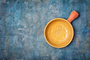 Top view on handmade pottery frying pan or bowl with yellow glaze