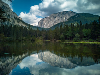 Fototapeta na wymiar Incredible mountain tree clouds panorama reflected in a lake