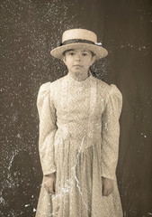 Replica antique formal photo with dust and scratches of little girl in 1900’s clothing