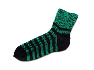 Hand knitted handmade natural wool striped pattern black and green warm sock accessory isolated on the white background 