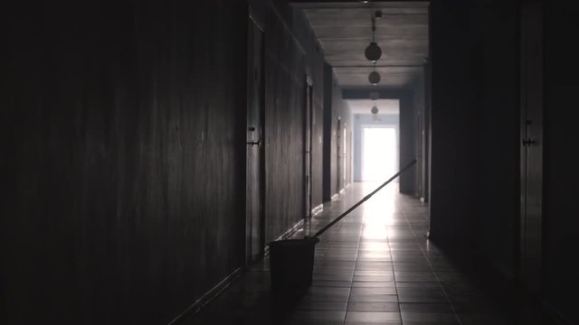 Tracking shot of empty hallway with mop and bucket on the floor