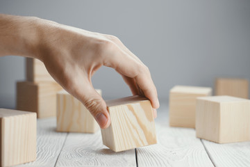 Hand putting a wooden cube among other cubes