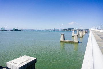 Fototapeta na wymiar The remaining pylons of the old Oakland - Yerba Buena bay bridge, San Francisco skyline in the background, California