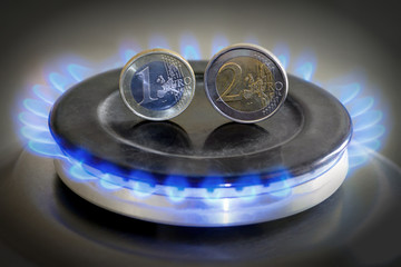 Burning natural gas and euro coins on gas hob