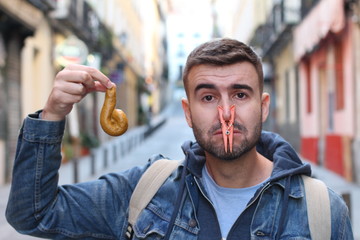 Disgusted man holding smelly poop