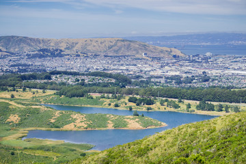San Andreas reservoir and the town of South San Francisco, the Industrial city, in the background; San Francisco bay, California