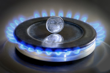 Gas hob with burning natural gas and Russian rouble coin