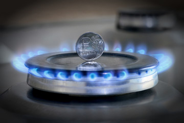 Gas hob with burning natural gas and Russian rouble coin