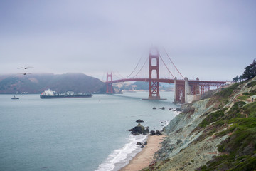 Cargo ship approaching Golden Gate Bridge on a foggy day, San Francisco, California