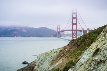 View towards Golden Gate bridge from the coastal trail on a foggy day, Presidio park, San Francisco, California
