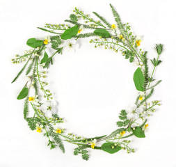 Round frame wreath made of spring flowers and leaves isolated on white background. Flat lay. Top...