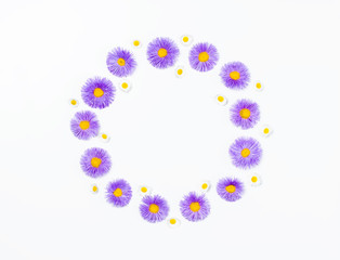 Floral wreath made of violet flowers and chamomile on white background. Flat lay. Top view with copy space.