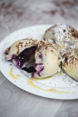 Czech or European typical meal, sweet stuffed dumplings, often with plum, strawberry or another fruit, served with chocolate, cocoa, butter and curd, eaten as a dessert after dish, liked by children