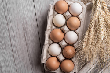 Raw eggs in egg box on wooden background.top view
