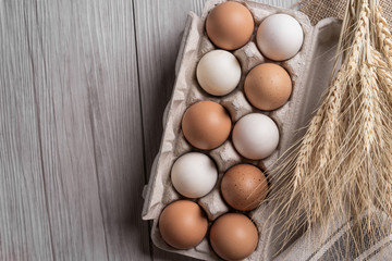 Raw eggs in egg box on wooden background.top view